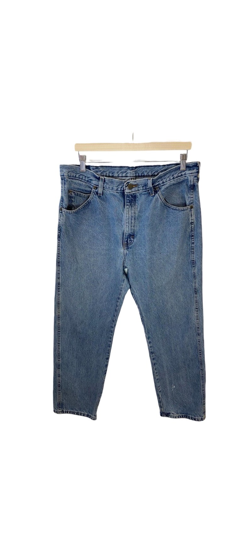 May include: A pair of light blue denim jeans with a classic five-pocket style. The jeans have a straight leg and a relaxed fit.