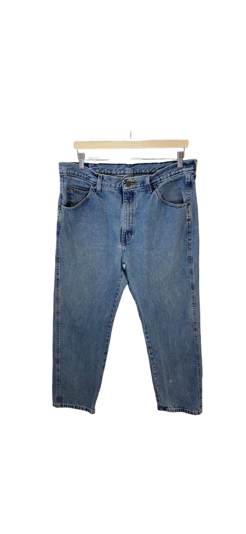 May include: A pair of light blue denim jeans with a classic five-pocket style. The jeans have a straight leg and a relaxed fit.