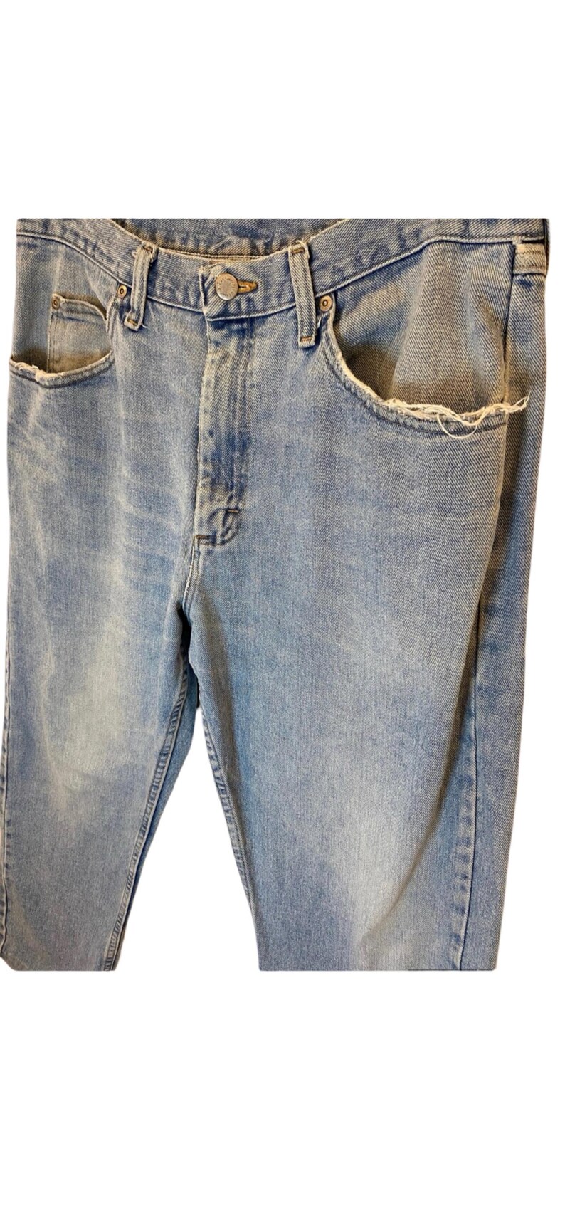 Peut inclure: Un jean en denim bleu clair avec une poche effiloch&eacute;e et une braguette &agrave; bouton.