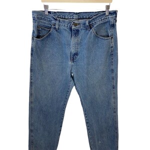 May include: A pair of light blue denim jeans with a classic straight leg fit. The jeans have a button fly and five pockets.
