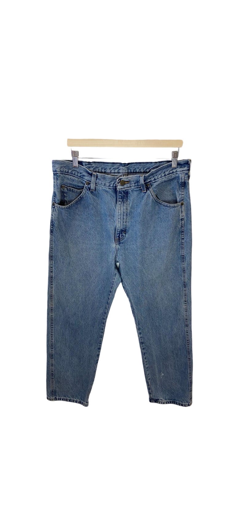 May include: A pair of light blue denim jeans with a classic straight leg fit. The jeans have a button fly and five pockets.
