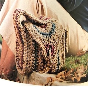 Op de afbeelding: Een gehaakte tas in bruin, blauw en bordeaux, met een flap en handvat. De afbeelding bevat de tekst "Fast & Easy" en "70's Crochet Pattern". De tas staat tegen een neutrale achtergrond.