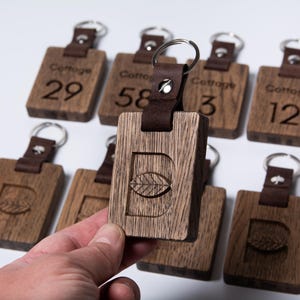 CNC Engraved Wood & Leather Keychain: Personalized bespoke Hotel Key Fob made from oak wood.