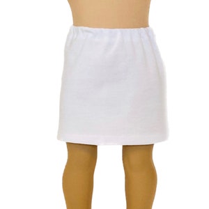 May include: A white, elastic-waist skirt. The skirt is made of a soft, opaque fabric and is knee-length. The skirt is designed for a doll.