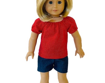 May include: A doll wearing a red polka dot top and denim shorts. The doll has blonde hair and blue eyes. The outfit is a casual style, suitable for play or display.