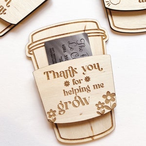Puede incluir: Etiqueta de regalo de madera en forma de taza de caf&eacute; con el texto "Gracias * por * ayudarme a crecer" y una ranura para una tarjeta de regalo. La etiqueta est&aacute; decorada con peque&ntilde;os dise&ntilde;os de flores.