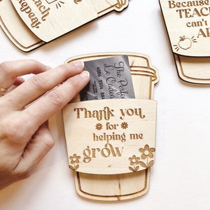 Puede incluir: Etiqueta de regalo de madera en forma de taza de caf&eacute; con el texto "Gracias por ayudarme a crecer" y un peque&ntilde;o dise&ntilde;o floral. La etiqueta est&aacute; dise&ntilde;ada para contener una tarjeta de regalo o dinero.