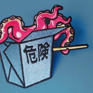 May include: A pink octopus with tentacles sticking out of a blue and white takeaway container with the Chinese character for "delicious" on the side. A yellow chopstick is sticking out of the container.
