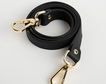 May include: Black leather shoulder strap with gold-toned hardware. The strap has two swivel clasps.