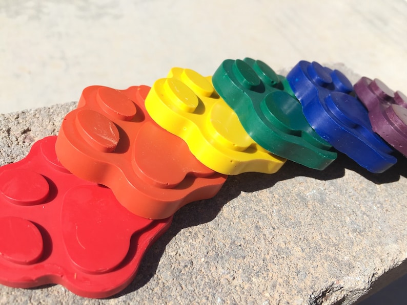 May include: A set of six paw print shaped silicone molds in rainbow colors: red, orange, yellow, green, blue, and purple.
