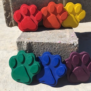 May include: Six colorful paw print shaped silicone molds. The molds are red, orange, yellow, green, blue, and purple.