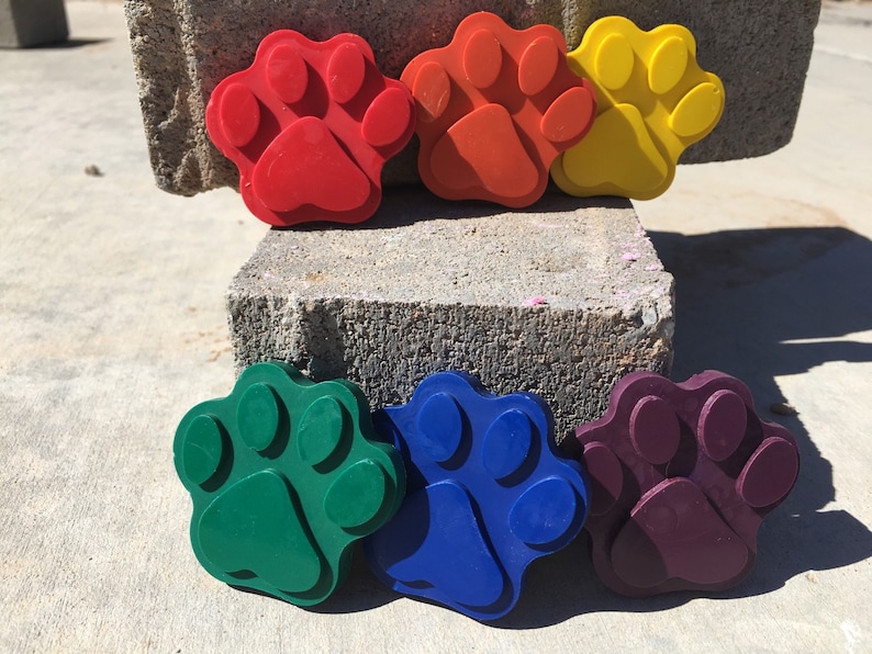 May include: Six colorful paw print shaped silicone molds. The molds are red, orange, yellow, green, blue, and purple.