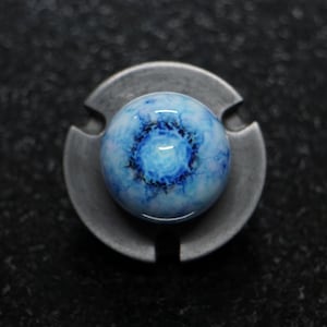 May include: A blue and white marble with a swirling pattern, set on a silver metal base.