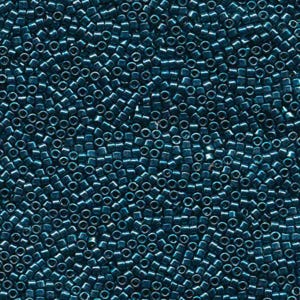 May include: Close-up of a dense collection of small, cylindrical beads in a deep teal color. The beads are uniform in size and shape, creating a textured surface. Ideal for jewelry making and crafts.