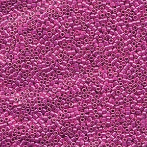 May include: A close-up view of a large quantity of small, shiny, pink beads. The beads are all the same size and shape, and they are arranged in a random pattern.