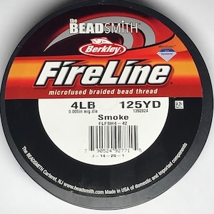 May include: A spool of black Berkley FireLine microfused braided bead thread fishing line. The spool is labeled with the text "FireLine", "microfused braided bead thread", "4LB", "125YD", "0.005in avg.dia", "1392824", "Smoke", "FLFSH4-42", and a barcode. The spool is also labeled with the text "The BEADSMITH Carteret, NJ www.beadsmith.com Made in USA of domestic and imported components".