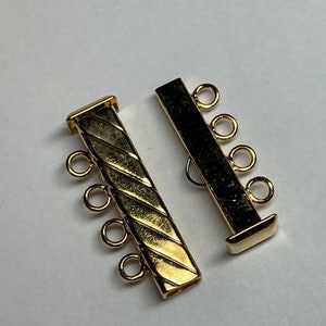 May include: Two gold-tone metal extender chain connectors with a diamond pattern. Each connector has four jump rings.