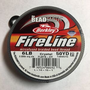 May include: A spool of 6lb FireLine Crystal microfused braided bead thread in a black and red container. The spool is 50 yards and has a 0.006in average diameter. The label also includes the text "The BEADSMITH Carteret, NJ www.beadsmith.com Made in USA of domestic and imported components".