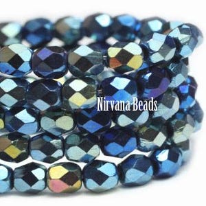May include: Close-up of a stack of faceted beads in shades of blue, green, and gold. The beads have a metallic sheen and are arranged in a spiral. The text "Nirvana Beads" is visible on the beads.