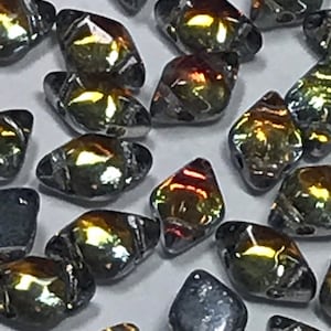 May include: A collection of iridescent glass beads in a diamond shape. The beads have a dark gray base with a rainbow sheen.