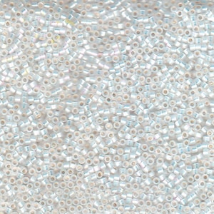 May include: A close-up view of a large quantity of small, white, iridescent seed beads. The beads are round and have a slight shimmer to them.