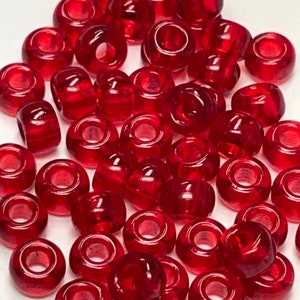 May include: A pile of red plastic beads, perfect for crafting projects.