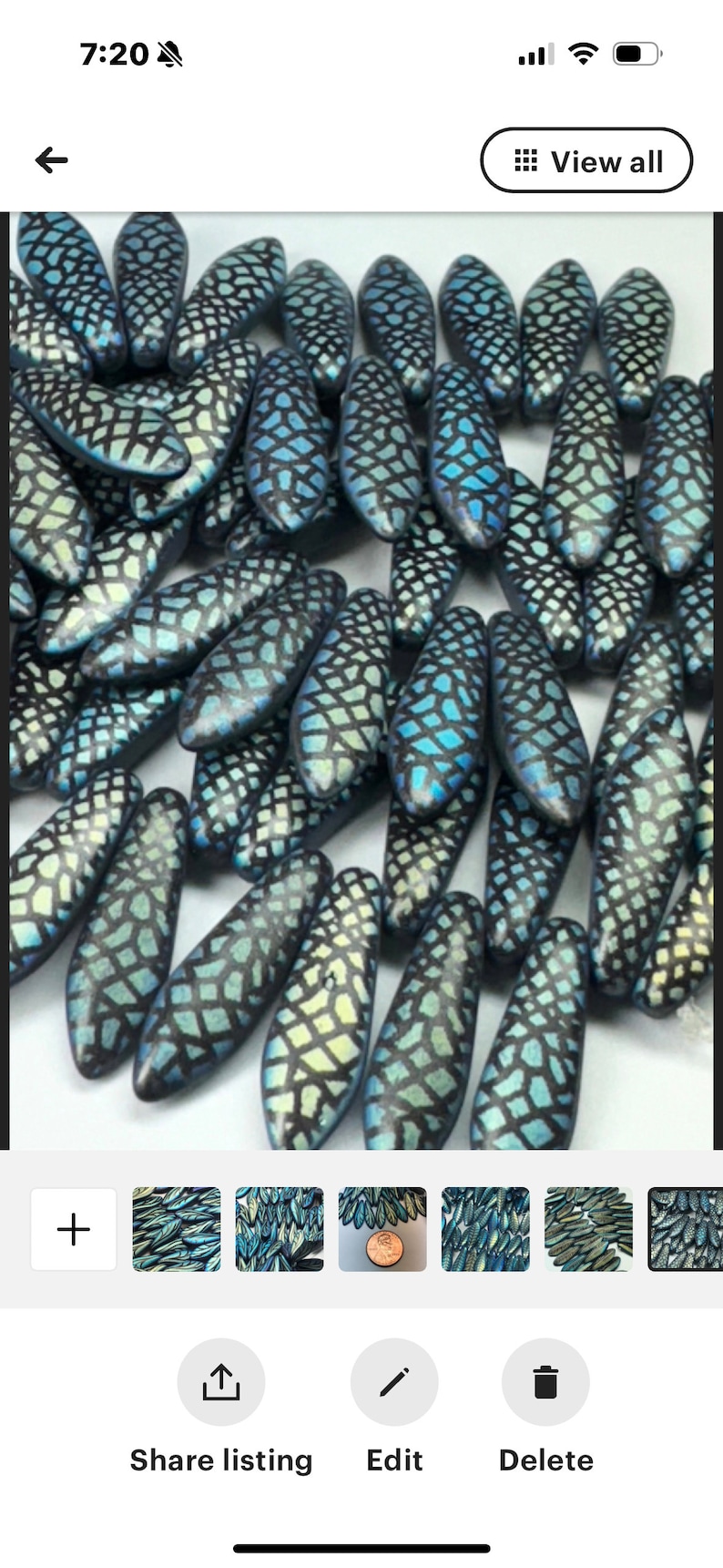 K&ouml;nnte beinhalten: Nahaufnahme einer Ansammlung von blauen und wei&szlig;en Glasperlen mit geometrischem Muster. Die Perlen sind oval geformt und haben eine gl&auml;nzende Oberfl&auml;che.