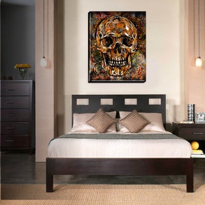 May include: A gold skull with intricate details is surrounded by a swirling pattern of orange, brown, and black. The skull is set against a dark background.