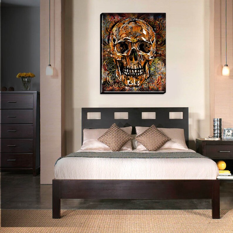 May include: A gold skull with intricate details is surrounded by a swirling pattern of orange, brown, and black. The skull is set against a dark background.