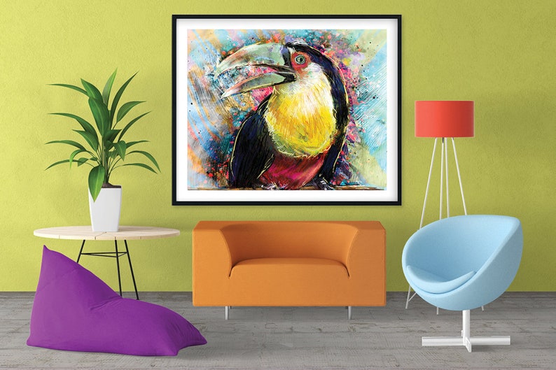 May include: A colorful abstract painting of a toucan with a large orange beak and yellow and red feathers. The painting is framed in black and set against a green wall.