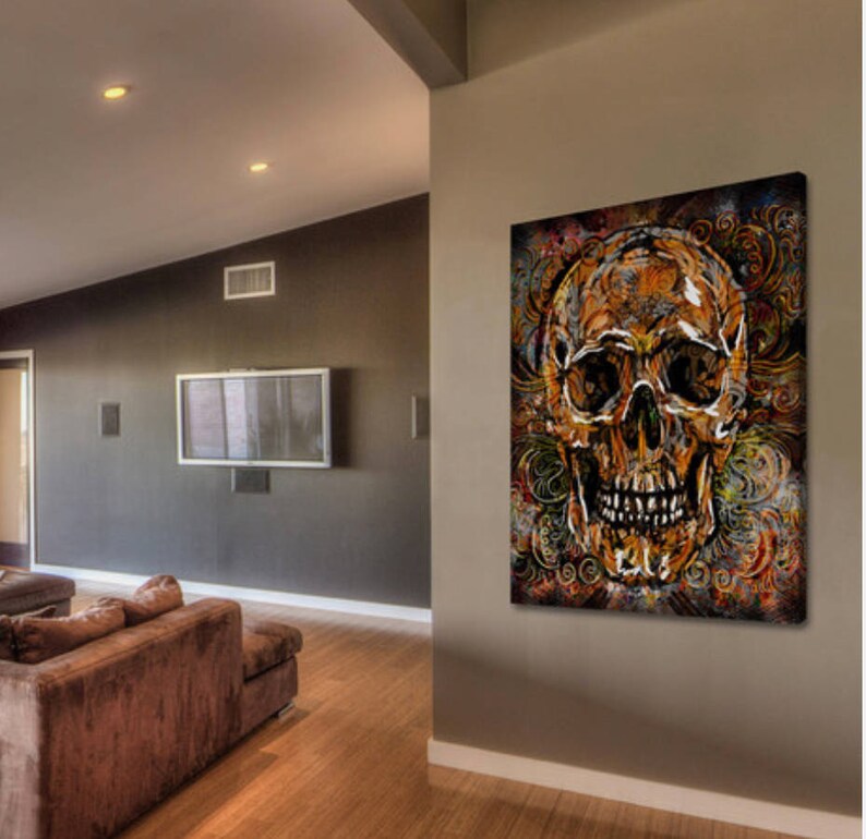 May include: A colorful abstract painting of a skull with intricate details. The skull is painted in shades of gold, brown, and red, and is surrounded by swirling patterns. The painting is set against a dark background.