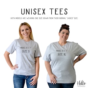 Op de afbeelding: Twee modellen dragen unisex t-shirts in een lichtgrijze kleur. Het model links draagt maat S en is 1,70 m lang. Het model rechts draagt maat XL en is 1,57 m lang. Beide modellen dragen jeans.