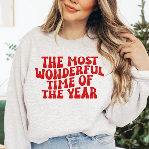 May include: A grey sweatshirt with the text "THE MOST WONDERFUL TIME OF THE YEAR" in red.
