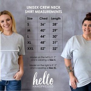 May include: Unisex crew neck t-shirt size chart with measurements in inches. The chart shows the chest and length measurements for sizes S, M, L, XL, and XXL. Two models are wearing the shirts, one in size S and one in size XL.