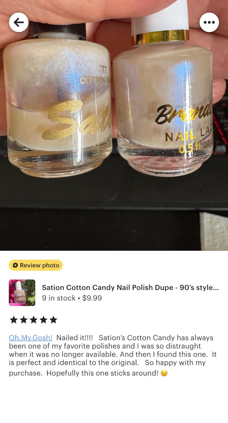 Peut inclure: Deux flacons de vernis &agrave; ongles iris&eacute;s. L'un porte l'inscription "77 Cotton Candy Sati" en lettres dor&eacute;es. L'autre porte l'inscription "Branda NAIL LAC 0,51 oz" en lettres dor&eacute;es.