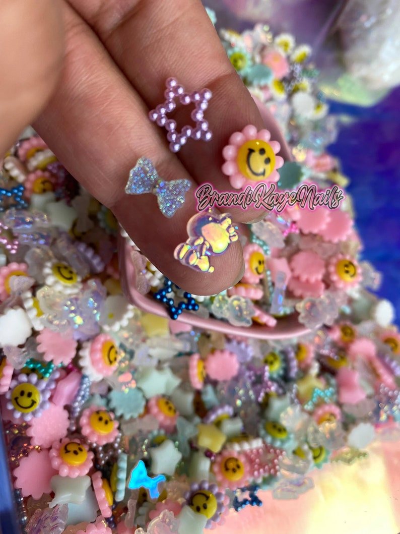 May include: A variety of colorful resin charms, including stars, flowers, and smiley faces. The charms are perfect for adding a touch of whimsy to crafts and nail art.