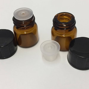 May include: Two amber glass bottles with black screw-on caps and white rubber stoppers. The bottles are empty and ready to be filled.