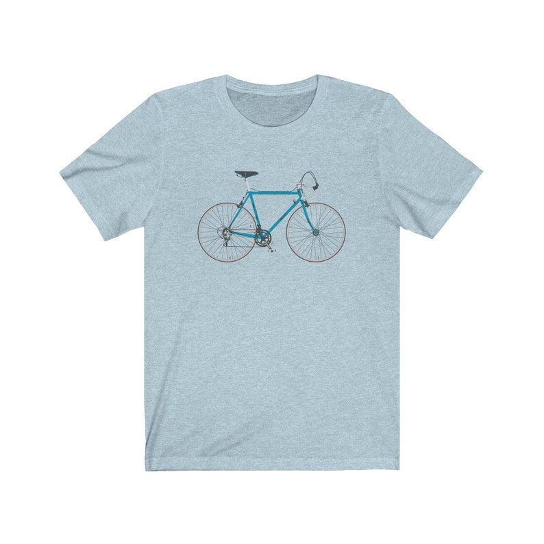 May include: A light blue bicycle with white tires and a black seat. The bicycle is on a light blue t-shirt.