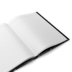 May include: A black notebook with a galaxy print cover. The notebook is open and has lined pages.