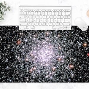 May include: A rectangular mouse pad featuring a vibrant image of a star cluster against a black background. A white keyboard and mouse are positioned above the pad, with a cup of coffee to the side. The pad measures approximately 30 inches long.