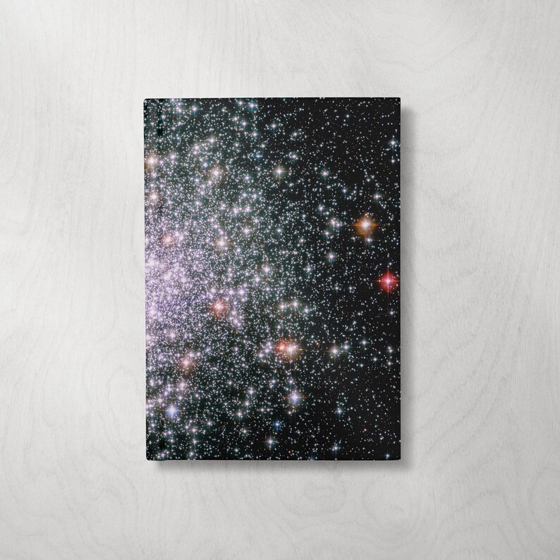 May include: A close-up image of a star cluster with a dark background. The cluster is filled with thousands of stars, some of which are brighter than others. The stars are arranged in a random pattern, creating a sense of depth and vastness.