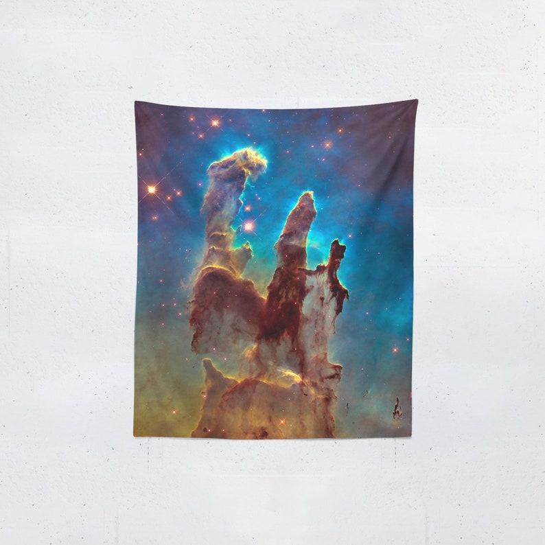 May include: A tapestry featuring a vibrant depiction of the Pillars of Creation, a nebula in the Eagle Nebula. The image showcases towering columns of gas and dust in shades of brown, yellow, and blue, with numerous bright stars scattered throughout.