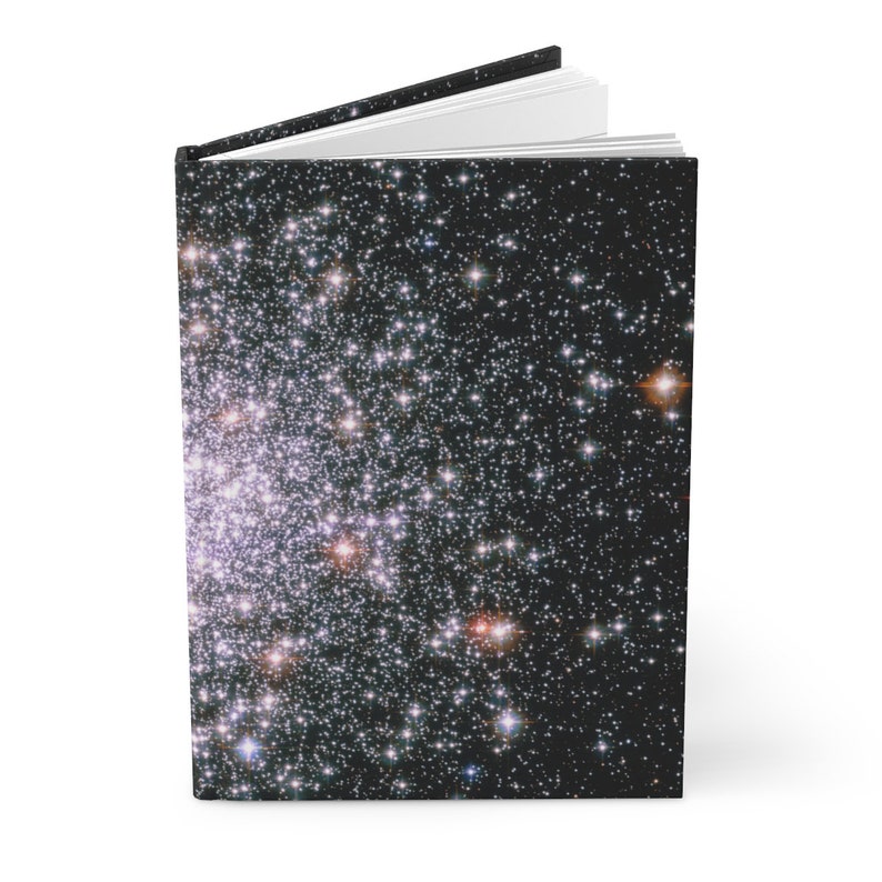 May include: A black and white notebook cover with a starry night sky design. The cover features a dense cluster of stars, with some appearing brighter than others.