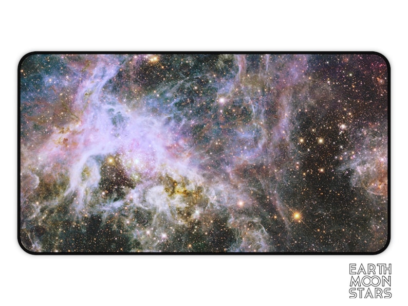 Puede incluir: Alfombrilla de escritorio rectangular con una imagen vibrante de una nebulosa con remolinos p&uacute;rpuras, azules y dorados. La alfombrilla tiene un borde negro y las palabras "EARTH MOON STARS" en blanco en la parte inferior derecha.