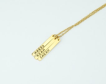 May include: Gold necklace with three vertical bar pendants, each engraved with a name: Harry, Noah, and Sarah.