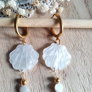 May include: Gold hoop earrings with white shell charms and white pearl accents.