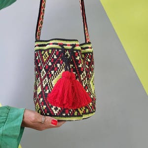 Handmade Ukrainian folk crochet bag shown from the back with long patterned shoulder strap.