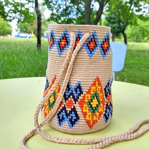 Crochet bucket bag side view showing woven strap
 Small cross body bag with colorful woven design