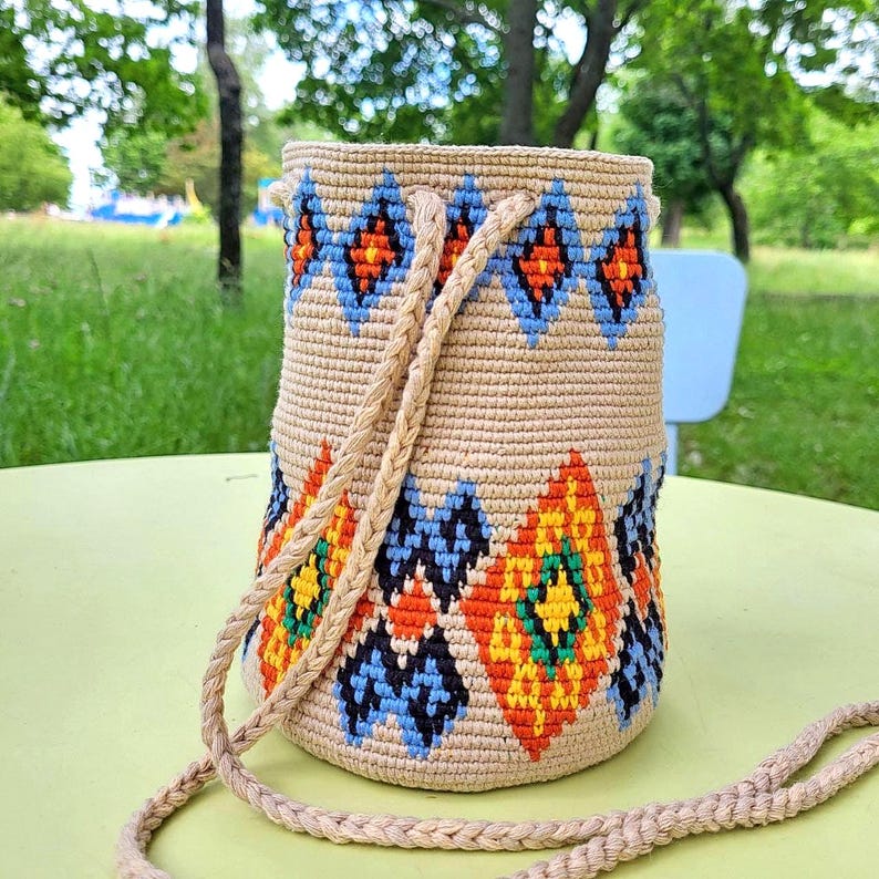 Crochet bucket bag side view showing woven strap
 Small cross body bag with colorful woven design