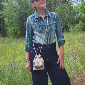 Mini bucket bag carried with embroidered outfit outdoors
 Everyday crossbody bag worn for casual summer walk